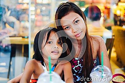 Happy bonding of two sisters in a cafe, sisters chilling in coffee-shop Stock Photo