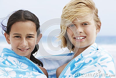 Happy Boy And Girl Wrapped In Towel Together At Beach Stock Photo