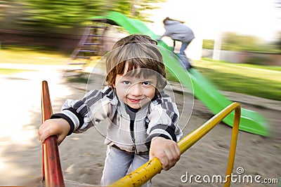 Happy boy having fun on carousel playground outdoors Stock Photo