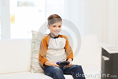 Happy boy with joystick playing video game at home Stock Photo