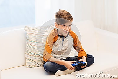 Happy boy with joystick playing video game at home Stock Photo