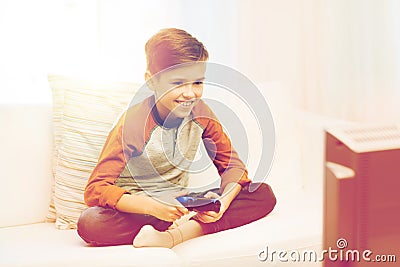 Happy boy with joystick playing video game at home Stock Photo