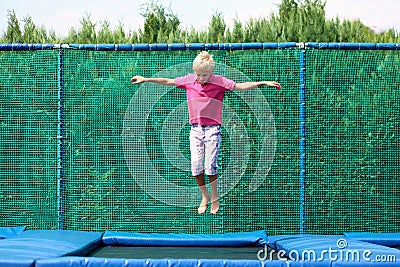 Happy boy jumping on trampoline Stock Photo