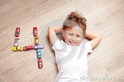 Happy boy playing on the floor with toys Stock Photo