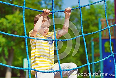 Happy boy playing at playground in summer Stock Photo