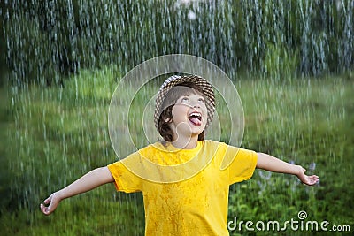 Happy boy in rain summer outdoors Stock Photo