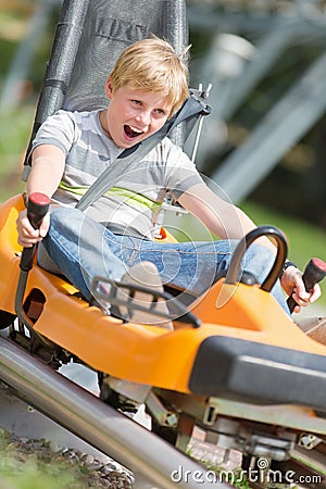 Happy boy riding at bobsled coaster rail trac Stock Photo