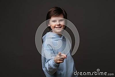 Happy boy is smiling and points at you with his index finger. I choose you. Facial expression concept Stock Photo