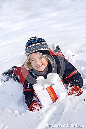 Happy boy in the snow with snowballs in a box Stock Photo