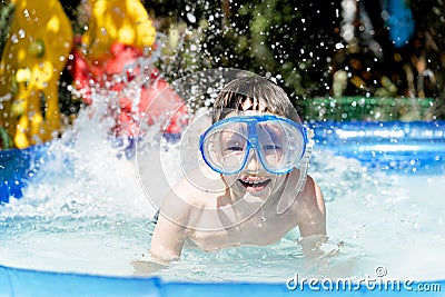 Happy boy in an underwater mask swimming in the pool Stock Photo