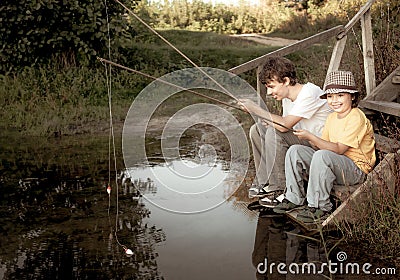 Happy boys go fishing on the river, Two children of the fisherman with a fishing rod on the shore of lake Stock Photo