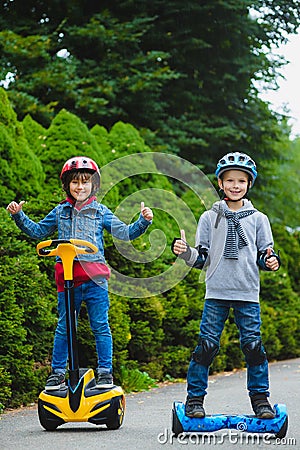 Happy boys riding on hoverboards or gyroscooters outdoor Stock Photo