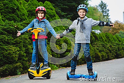 Happy boys riding on hoverboards or gyroscooters outdoor Stock Photo