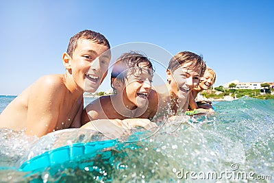 Happy boys swimming in the sea on air mattress Stock Photo