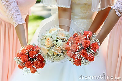 happy bride and bridesmaids showing their luxury bouquets at gorgeous wedding reception Stock Photo