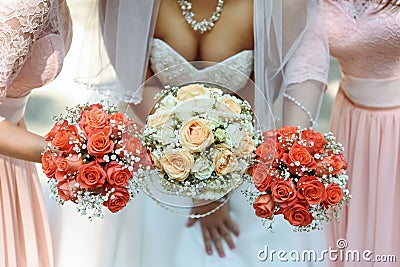 happy bride and bridesmaids showing their luxury bouquets at gorgeous wedding reception Stock Photo