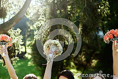 Happy bride and bridesmaids showing their luxury bouquets in han Stock Photo