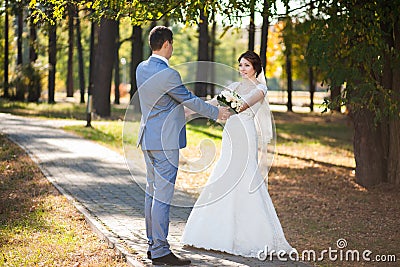 Happy bride, groom dancing in green park, kissing, smiling, laughing. lovers in wedding day. happy young couple in love. Stock Photo