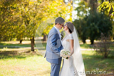 Happy bride, groom dancing in green park, kissing, smiling, laughing. lovers in wedding day. happy young couple in love. Stock Photo