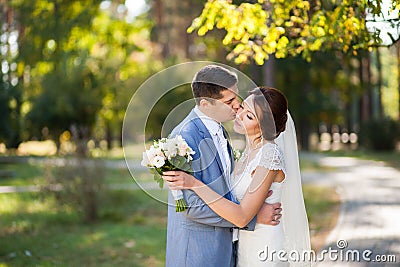 Happy bride, groom dancing in green park, kissing, smiling, laughing. lovers in wedding day. happy young couple in love. Stock Photo