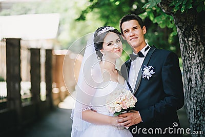 Happy bride and groom posing in a park Stock Photo