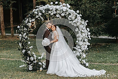 Happy bride and groom after wedding ceremony. round ceremonial arch. Stock Photo