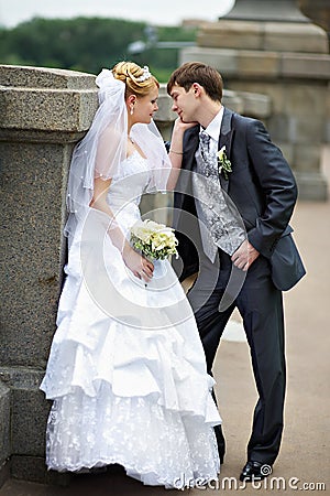 Happy bride and groom at wedding walk on bridge Stock Photo