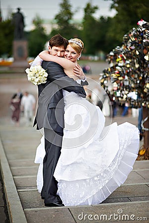 Happy bride and groom at wedding walk on bridge Stock Photo