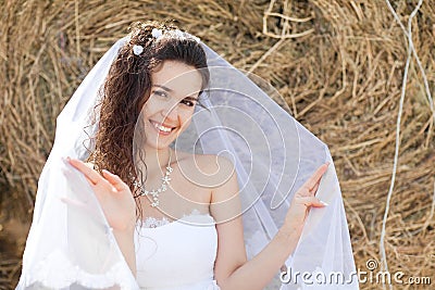 Happy bride near hay Stock Photo