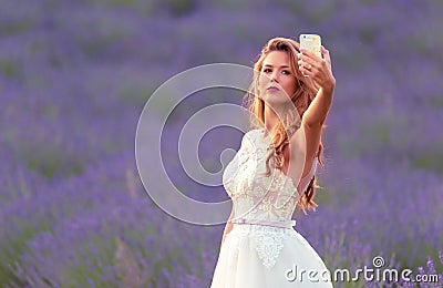 Happy bride take a selfie with her phone in lavender field Stock Photo