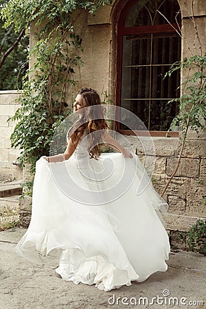 Happy bride woman running in wedding dress at park Stock Photo