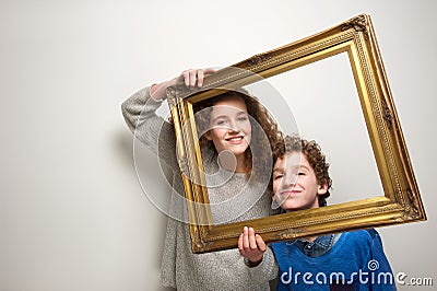 Happy brother and sister holding picture frame Stock Photo