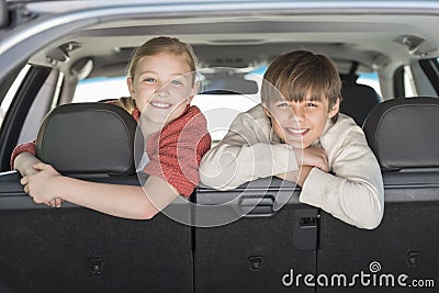 Happy Brother And Sister Leaning On Car Seat Stock Photo
