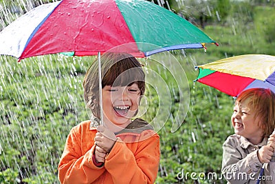 Happy brother with umbrella outdoors Stock Photo