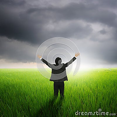 Happy business man in green rice field and rainclouds Stock Photo