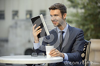 Happy Business Man sitting reading his planner while drinking coffee Stock Photo