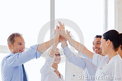 Happy business team giving high five in office Stock Photo