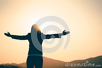 Happy business woman spreading arms and watching the mountain silhouette. Business success concept, freedom emotions Stock Photo