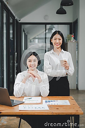 Happy business woman standing competently and smiling in open plan office Stock Photo