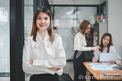 Happy business woman standing competently and smiling in open plan office Stock Photo