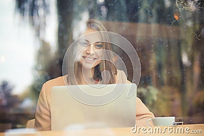 Happy business woman student smiling looking at you with computer in coffee shop Stock Photo