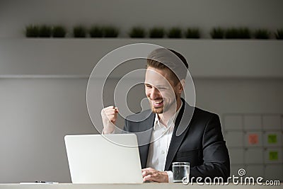 Happy businessman celebrating business success online win lookin Stock Photo