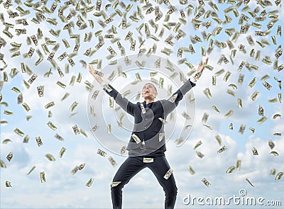 Happy businessman in celebrating pose with loads of money in the air Stock Photo