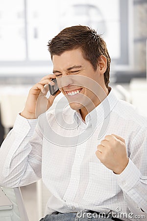 Happy businessman getting good news on phone Stock Photo