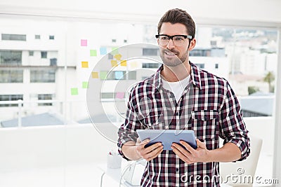 Happy businessman with glasses holding tablet Stock Photo