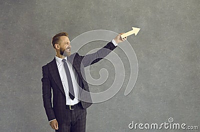 Happy businessman holding arrow going up as symbol of business growth and success Stock Photo