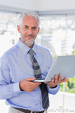 Happy businessman holding laptop Stock Photo