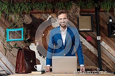 Happy businessman laughing while standing behind a desk Stock Photo