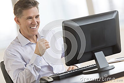 Happy Businessman Looking At Computer Monitor Stock Photo