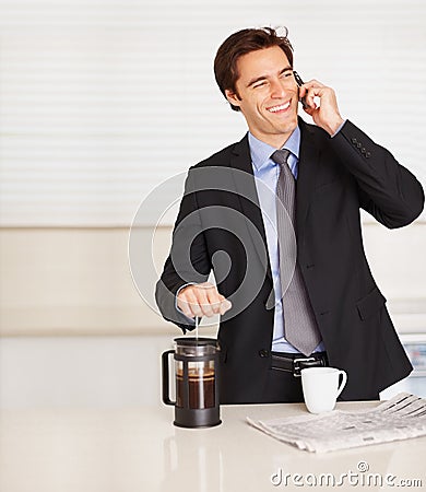 Happy businessman, phone call and coffee for discussion or communication in kitchen at home. Man or employee smile and Stock Photo